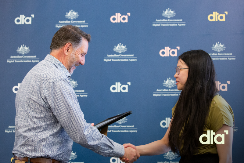 Person shaking hands with another while accepting a certificate