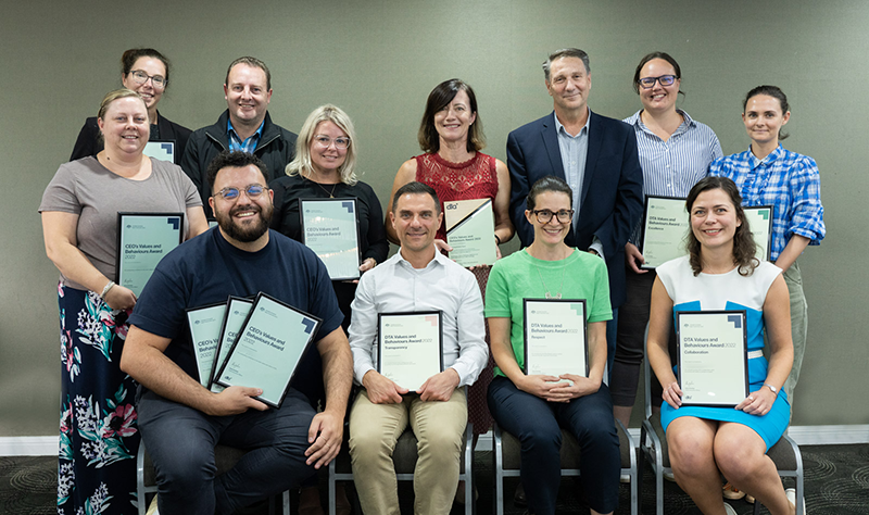 A group of 12 people smiling and holding certificates 